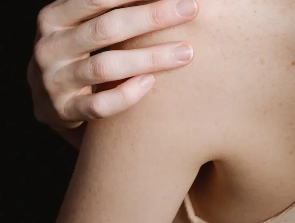 imagen macro de una mano examinando texturas e irregularidades en la superficie de la piel, con iluminación suave y tonos naturales.